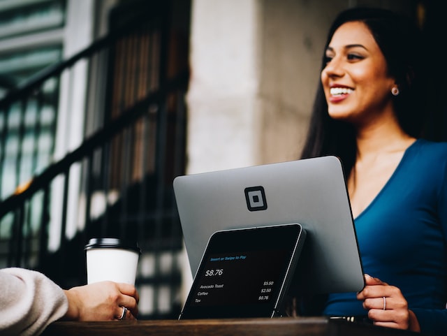 A girl smiling sitting behind iot device